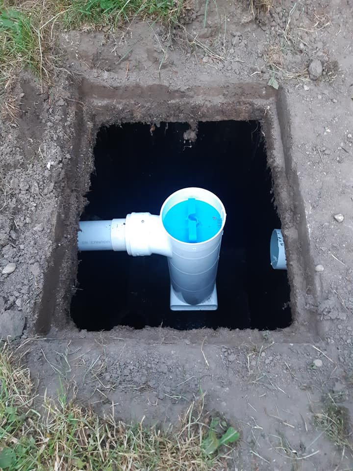 picture of a septic tank with the lid open, showing the riser pipe